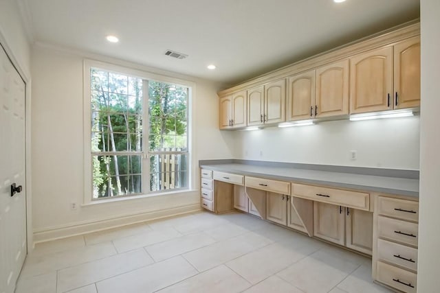 interior space featuring crown molding, light tile patterned floors, and built in desk