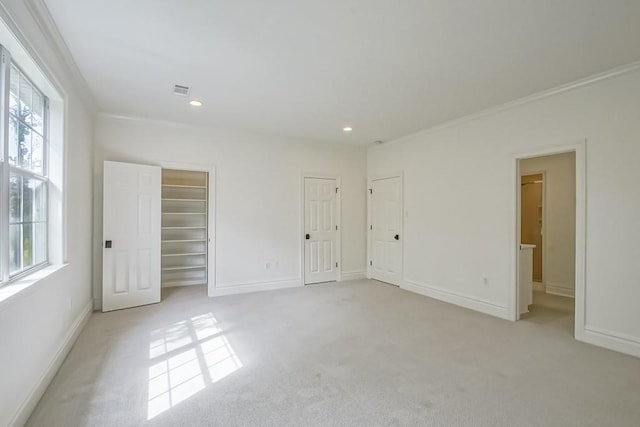 carpeted empty room featuring a healthy amount of sunlight and ornamental molding