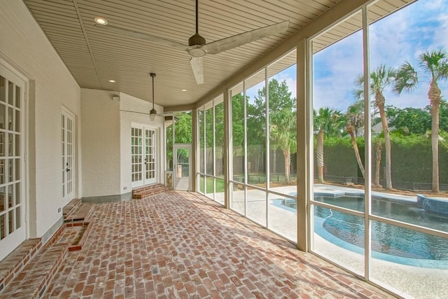 unfurnished sunroom with ceiling fan