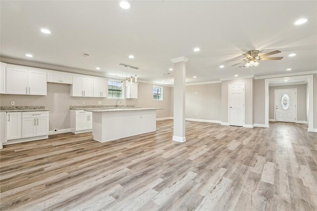 kitchen featuring light hardwood / wood-style floors, crown molding, and white cabinets