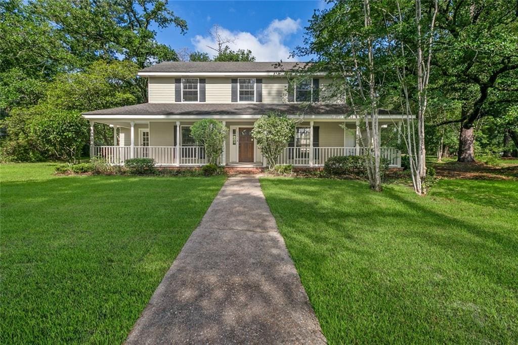 farmhouse inspired home featuring a front lawn and a porch