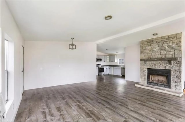 unfurnished living room with a fireplace, dark hardwood / wood-style flooring, and vaulted ceiling