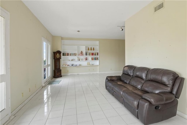 living room with rail lighting and light tile patterned floors