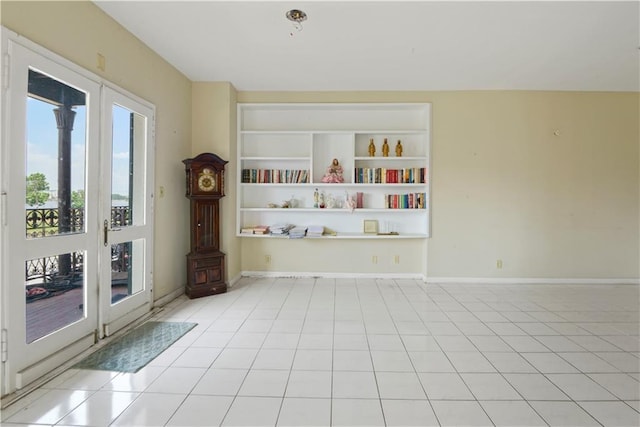 tiled empty room featuring french doors