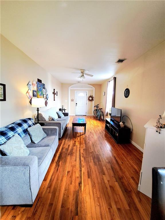 living room featuring ceiling fan and dark hardwood / wood-style flooring