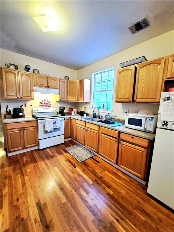 kitchen featuring sink, white appliances, and dark wood-type flooring