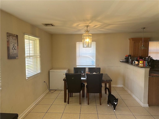 tiled dining area with a chandelier