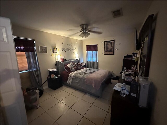 tiled bedroom with multiple windows and ceiling fan