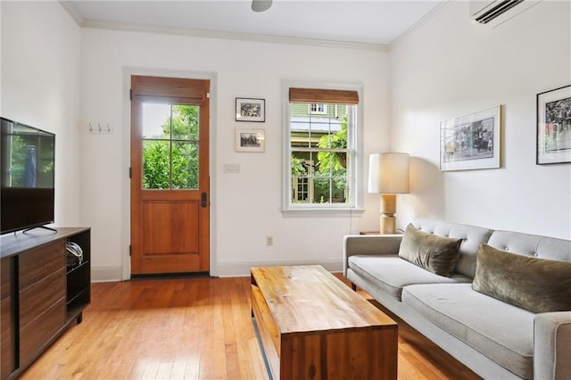 living room featuring light hardwood / wood-style flooring, a wall mounted AC, and crown molding