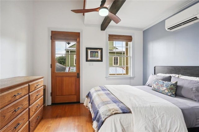 bedroom featuring ceiling fan, light wood-type flooring, an AC wall unit, and ornamental molding