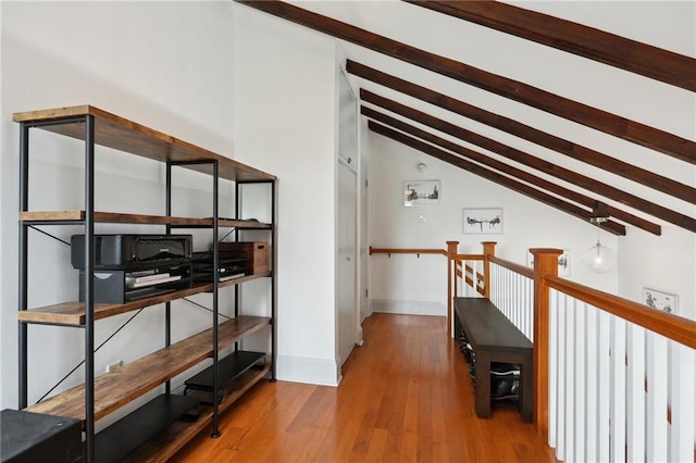 hallway with hardwood / wood-style flooring and lofted ceiling with beams