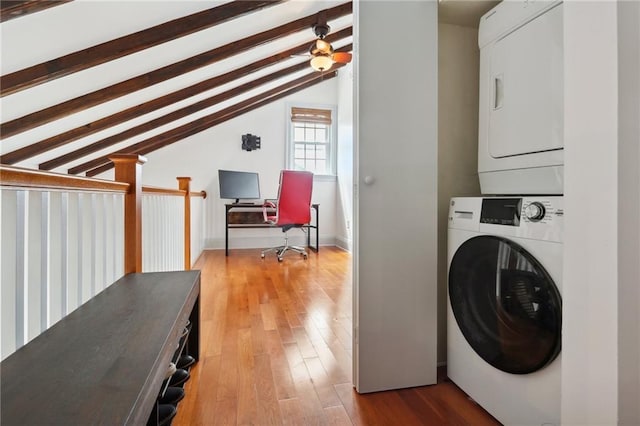 washroom with stacked washer and dryer and light hardwood / wood-style floors