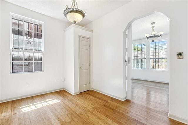 unfurnished room featuring hardwood / wood-style floors and a notable chandelier