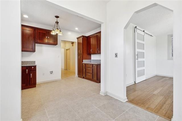 kitchen featuring hanging light fixtures and a barn door