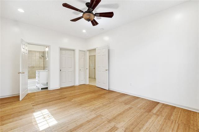 unfurnished bedroom with ensuite bathroom, ceiling fan, and light hardwood / wood-style flooring