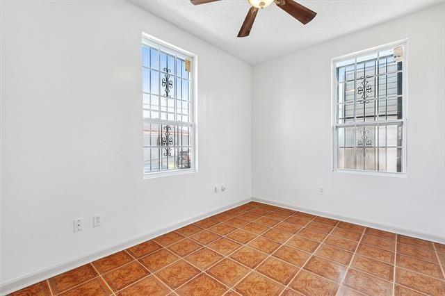 tiled spare room featuring ceiling fan