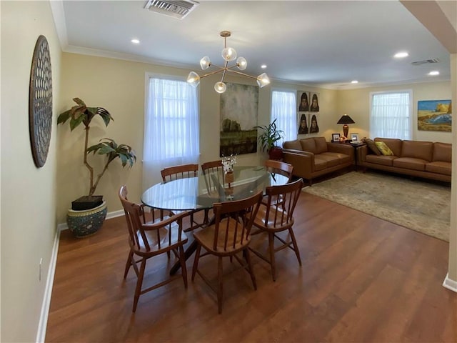 dining room with baseboards, dark wood finished floors, visible vents, and crown molding