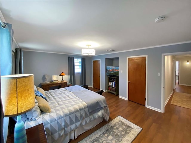 bedroom featuring dark wood-type flooring, crown molding, and baseboards