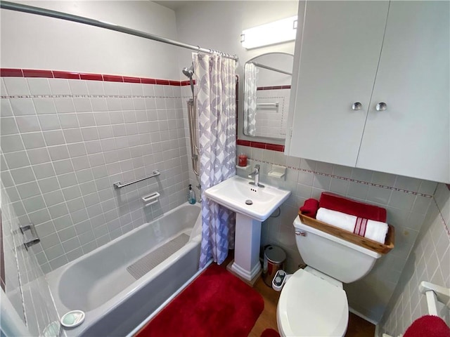 full bath with toilet, tile walls, and shower / bathtub combination with curtain