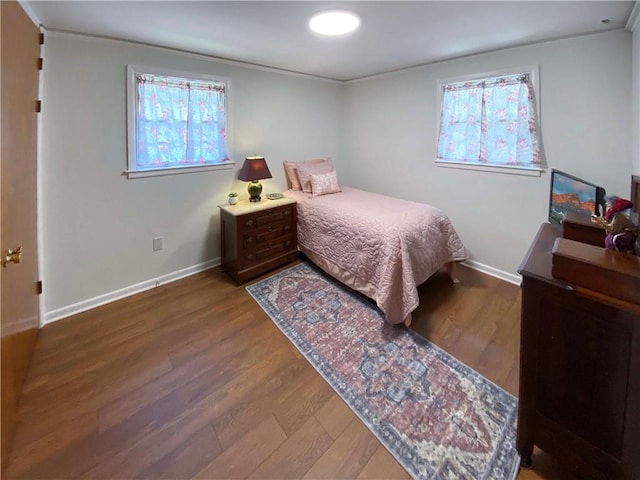 bedroom with baseboards, wood finished floors, and ornamental molding