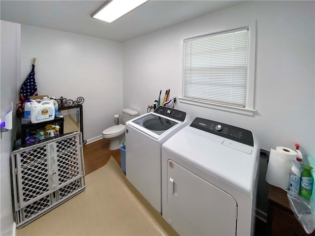 clothes washing area featuring light wood-type flooring, washing machine and dryer, and laundry area