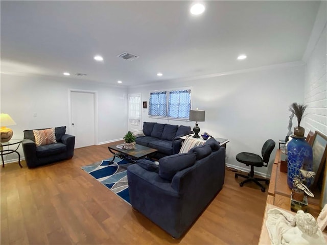 living room featuring visible vents, ornamental molding, wood finished floors, and recessed lighting