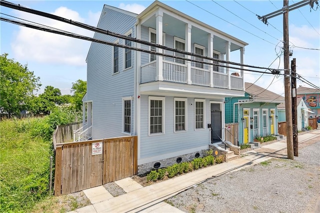 view of front of house featuring a balcony and entry steps