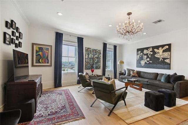 living room featuring ornamental molding, a chandelier, and light hardwood / wood-style flooring