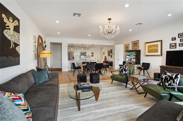 living room with crown molding, an inviting chandelier, and light hardwood / wood-style flooring