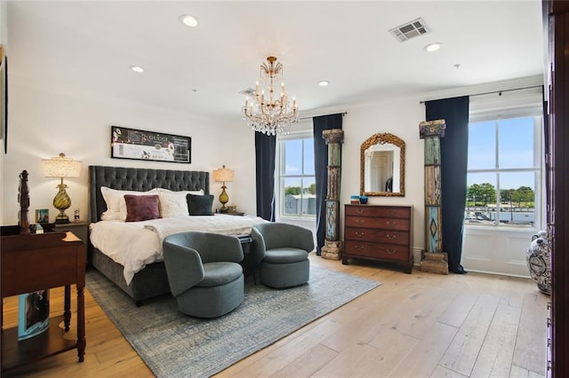 bedroom with a notable chandelier and light hardwood / wood-style floors