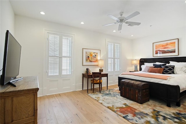 bedroom with multiple windows, ceiling fan, and light hardwood / wood-style flooring