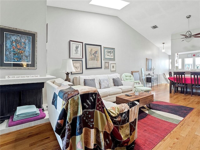 living room featuring hardwood / wood-style floors, vaulted ceiling, and ceiling fan