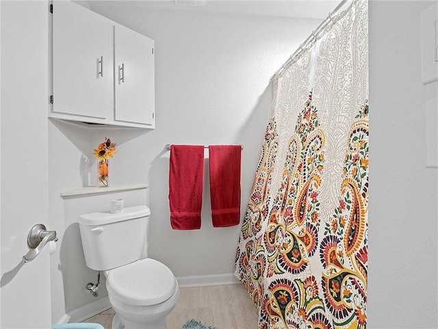 bathroom with hardwood / wood-style flooring and toilet