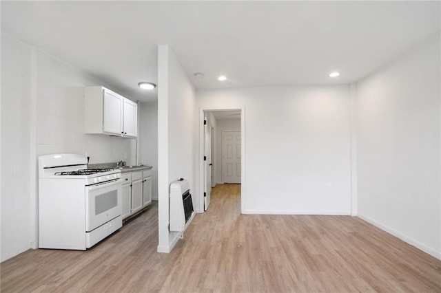 3300 Baronne St, New Orleans, LA 70115 - kitchen with white gas range oven, light wood finished floors, heating unit, and recessed lighting