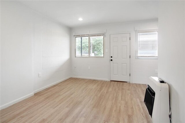 3300 Baronne St, New Orleans, LA 70115 - entryway featuring heating unit, concrete block wall, light wood-type flooring, baseboards, and recessed lighting