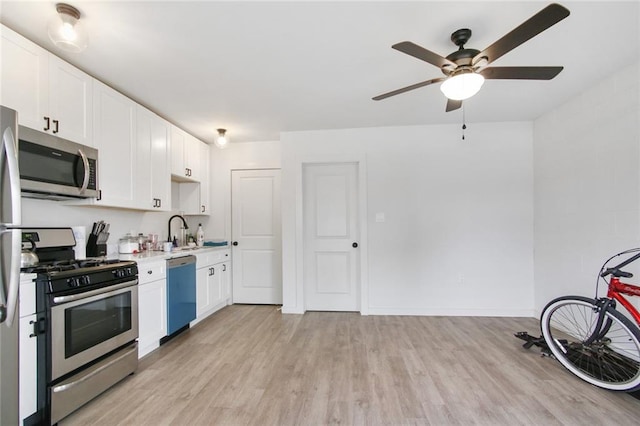 kitchen with light hardwood / wood-style flooring, white cabinets, and appliances with stainless steel finishes