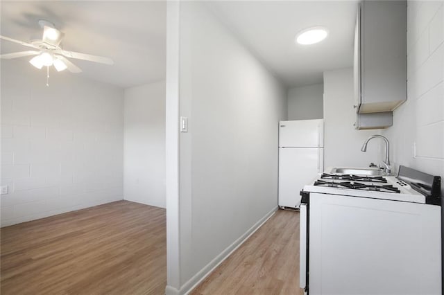 kitchen featuring light wood-type flooring, white appliances, ceiling fan, and sink