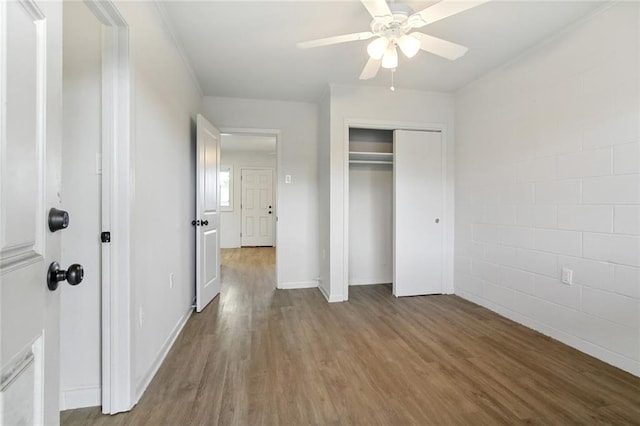 unfurnished bedroom featuring ceiling fan, light hardwood / wood-style flooring, crown molding, and a closet