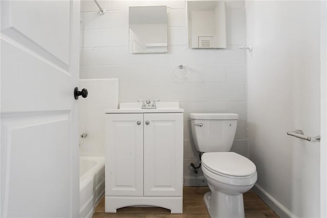 3300 Baronne St, New Orleans, LA 70115 - full bathroom featuring a bathing tub, toilet, vanity, and wood finished floors