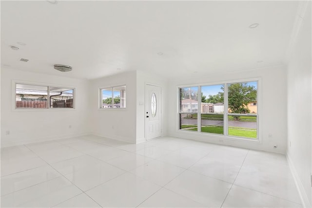 interior space featuring light tile patterned floors, plenty of natural light, and crown molding