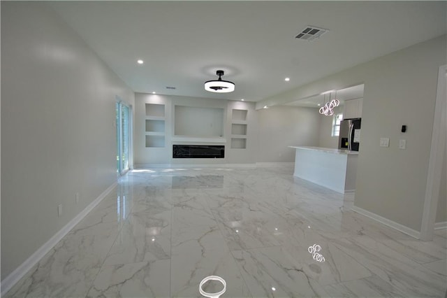 unfurnished living room featuring built in shelves and a fireplace