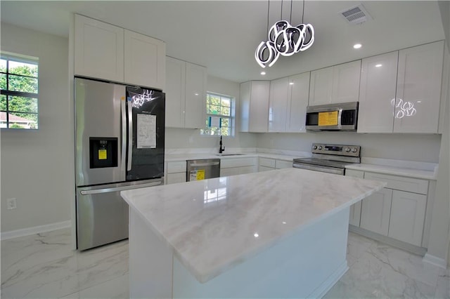 kitchen with white cabinets, a kitchen island, and stainless steel appliances