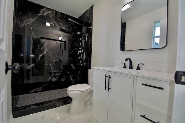 bathroom with a tile shower, vanity, and toilet