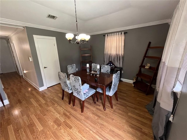 dining room featuring an inviting chandelier, wood-type flooring, and ornamental molding