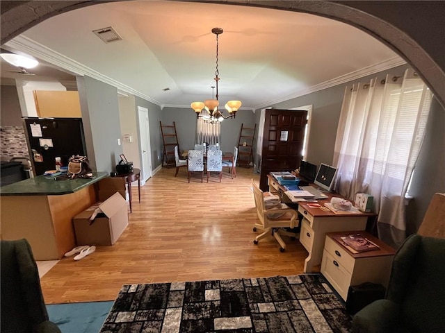 dining area with light wood-type flooring, crown molding, and a notable chandelier