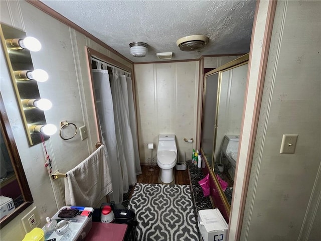 bathroom featuring a textured ceiling, curtained shower, and toilet