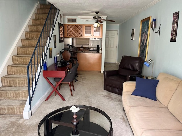 living room with light carpet, ceiling fan, a textured ceiling, and crown molding