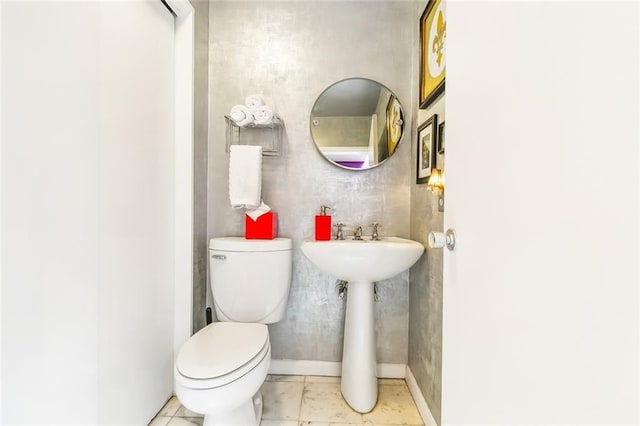 bathroom featuring tile flooring and toilet