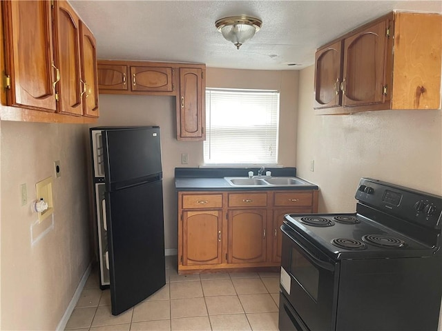 kitchen with sink, light tile patterned floors, and black appliances