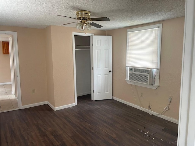 unfurnished bedroom featuring dark hardwood / wood-style floors, cooling unit, ceiling fan, a textured ceiling, and a closet